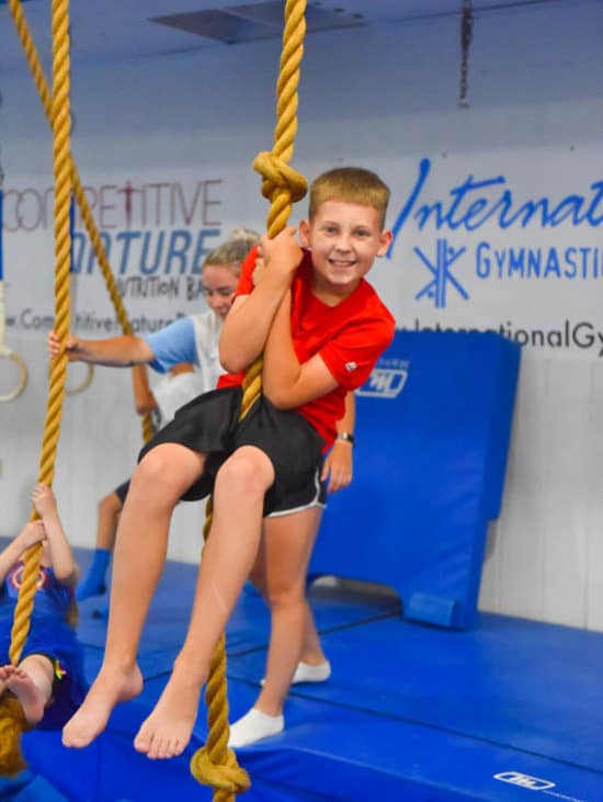 Boy swinging on rope in class