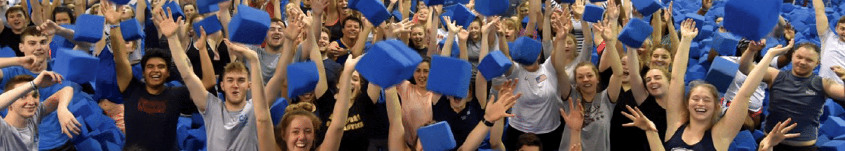 Coaches throwing foam blocks in the air for group photo