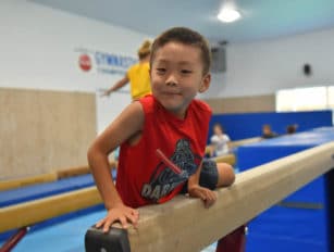 Boy getting on the balance beam