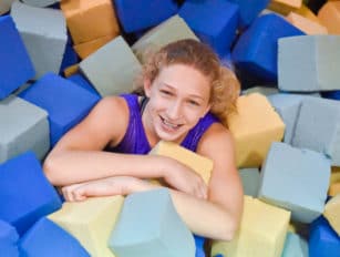 Girl in a pile of foam cubes