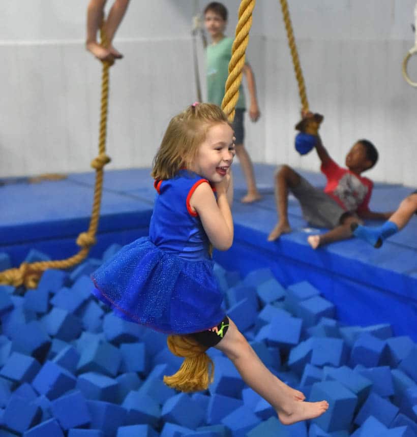 Young girl swinging on a rope